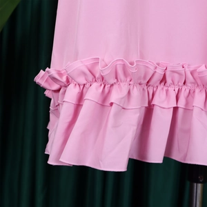 Close-up of double-layered ruffle hem on a pink A-line dress with detailed stitching