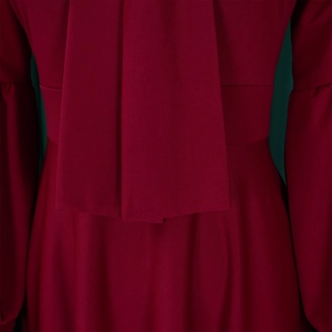 Detail view of the elegant burgundy maxi dress with waist tie and pleated fabric texture