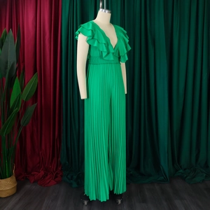 Détail d'une combinaison vert émeraude avec col en V, volants et pantalon large plissé