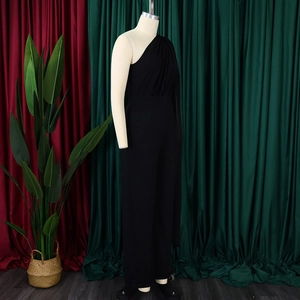 Detail of the elegant one-shoulder black jumpsuit with pleated waist and wide leg fit