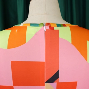 Détail du col rond et de la fermeture éclair invisible sur robe imprimée colorée