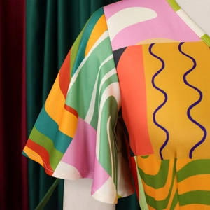 Détail du tissu à imprimé géométrique coloré et manche à volants sur la robe