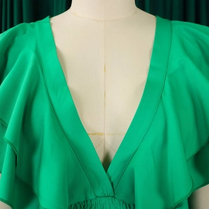 Détail du décolleté en V plongeant et des manches à volants sur une combinaison verte