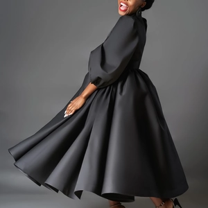 Dynamic side view of black satin midi dress featuring puff sleeves and flared skirt