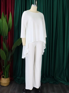Detail of white two-piece set with asymmetrical high-low hem and side ruffle on long top