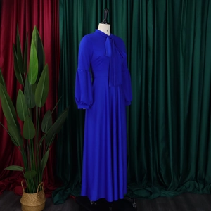 Detail of royal blue maxi dress featuring a tie neck bow and puff lantern sleeves