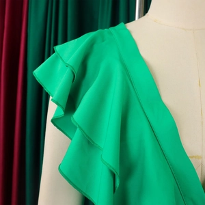 Détail d'une combinaison vert vif avec des volants à trois couches sur la bretelle