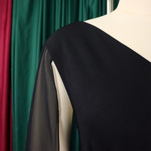 Détail du haut à col en V avec manches en tulle transparent sur un mannequin de mode