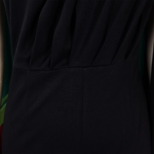 Close-up of elegant pleated waist design and fabric texture on a black one-shoulder jumpsuit