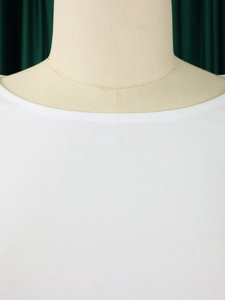 Detail of white crewneck top showing fine knitted texture and precise collar stitching