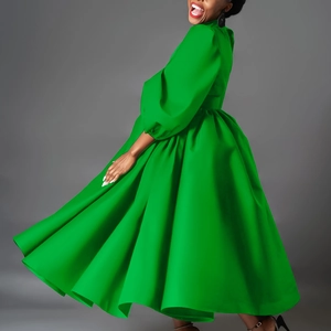 Dynamic view of bright green maxi dress with puff sleeves and wide voluminous hemline