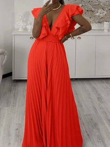 Détail macro du combishort rouge avec décolleté en V, volants et tissu plissé élégant