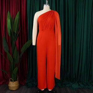 Detail of orange one shoulder jumpsuit with pleated cape and wide leg trousers