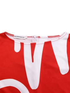 Detail of round neckline with red abstract print, invisible zipper, and brand woven label