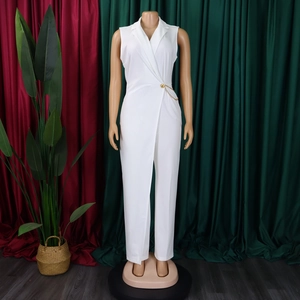 Detail view of white sleeveless jumpsuit featuring a lapel collar and golden chain belt