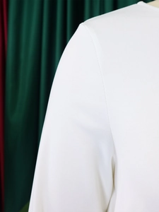 Detail view of the fine stitching and texture on the white knitted elegant two-piece set