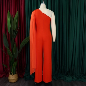 Detail of bright orange one-shoulder jumpsuit featuring an elegant long chiffon cape