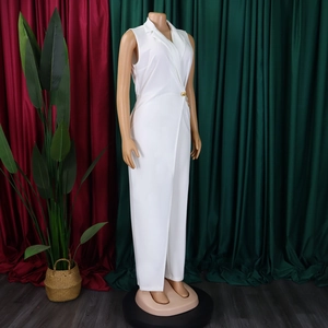 Detailed view of white sleeveless jumpsuit with notched collar and gold chain waist detail