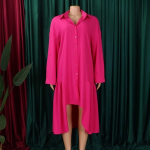 Detail of rose red shirt dress featuring a lapel collar and irregular ruffled hemline