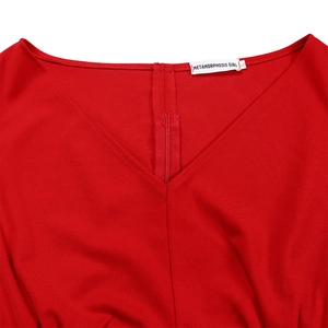 Détail du haut rouge à col en V montrant la texture du tissu et la fermeture éclair invisible
