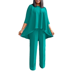 Detail of teal two-piece set featuring asymmetrical layered top and wide-leg trousers