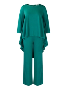 Detail of emerald two-piece set featuring asymmetrical ruffled hem top and wide-leg pants