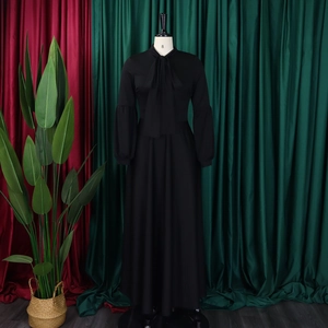 Detailed view of puff sleeves and bow-tie neckline on this elegant black maxi dress