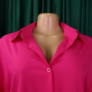 Close-up detail of the classic collar and single-breasted buttons on a bright rose pink shirt