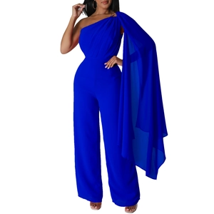 Detail of royal blue one-shoulder jumpsuit featuring a long flowing chiffon cape on the side