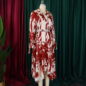Détail d'une robe fleurie rouge et blanche avec manches nouées et boucle de ceinture strass