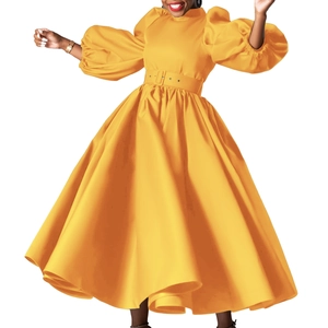 Detail of bright yellow maxi dress with puff sleeves and matching buckle waist belt