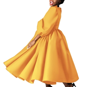 Close-up of vibrant orange puffed sleeves and flowy wide hem on this stylish midi dress