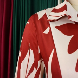 Gros plan du col de chemise à imprimé floral rouge et blanc avec texture satinée