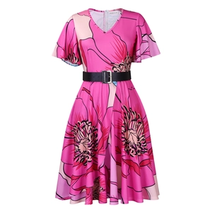 Détail d'une robe fleurie rose avec col en V, manches volantées et ceinture noire