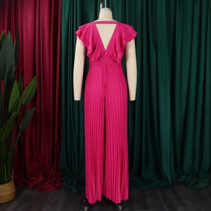 Détail d'une combinaison plissée fuchsia avec dos en V profond et volants aux épaules