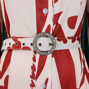 Détail d'une robe chemisier à imprimé floral avec ceinture à boucle en strass