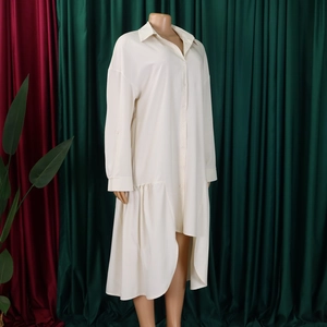 Detail of cream long sleeve shirt dress featuring asymmetrical ruffled high-low hemline