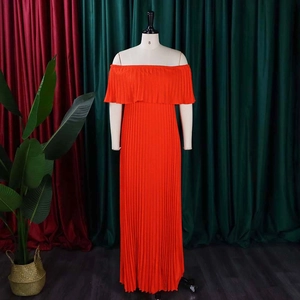 Detailansicht der Faltenstruktur an einem orangefarbenen schulterfreien Maxikleid