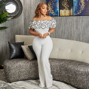 Detail of elegant off-shoulder ruffled neckline with black trim on white jumpsuit