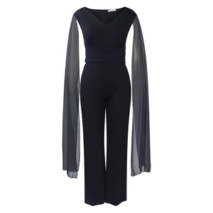 Détail d'une combinaison noire col en V avec manches cape en mousseline et taille plissée