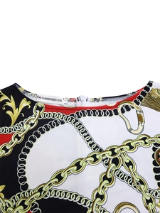 Close-up of elegant baroque floral print dress with golden chains and round neckline
