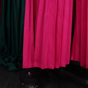 Détail de la combinaison plissée rose fuchsia avec texture satinée et ourlet du bas