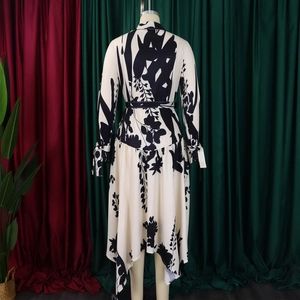 Détail d'une robe fleurie montrant la ceinture et l'ourlet irrégulier fluide