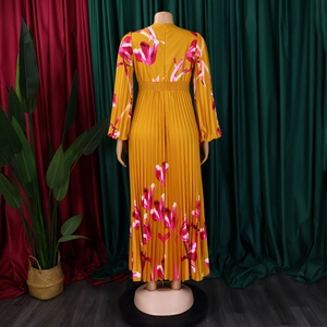 Dettaglio vestito floreale giallo a vita alta con gonna a pieghe e lunghe maniche a lanterna