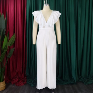 Détail d'une combinaison blanche à col en V profond avec volants et pantalon large plissé fin