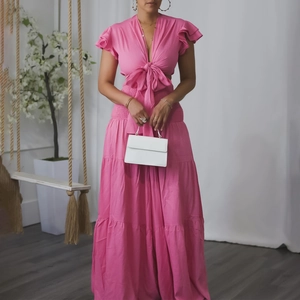 Détail du crop top rose à nouer et jupe longue à volants avec manches volantées