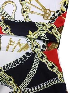 Detail of baroque print dress with gold chain and key patterns on red and black fabric