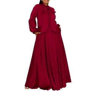 Detail of burgundy satin dress showing puff sleeves, tie neck, and hidden side pockets