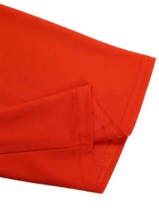 Detail of red knit fabric featuring precise double-needle stitching and overlock seams