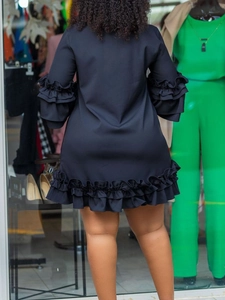 Back view of black long sleeve A-line dress with triple-layered flared ruffle cuffs
